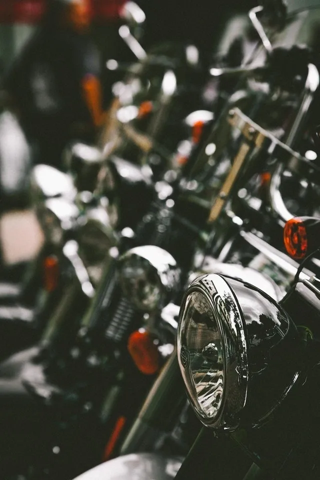 A row of motorcycles parked in a parking lot.