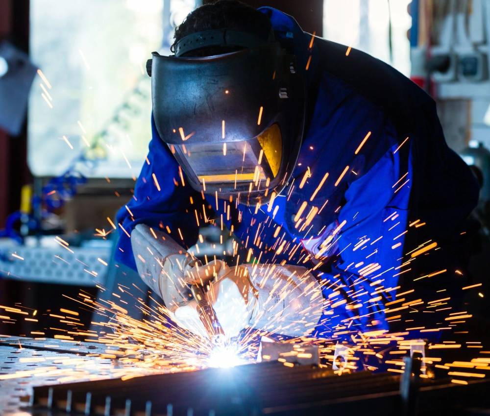 A person welding with sparks flying from the head.